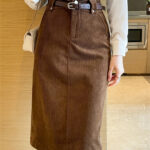 Jupe midi marron en velours portée avec une chemise blanche