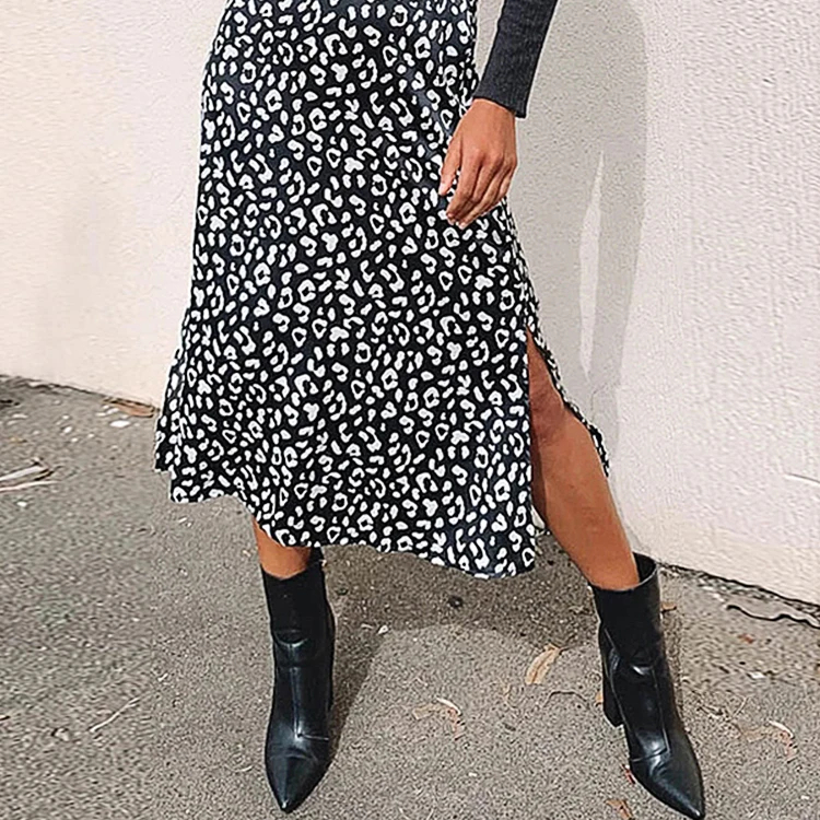 Femme portant une jupe fendue imprimé léopard et des bottes noires.