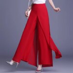 Femme portant un pantalon jupe rouge et des talons aiguilles.
