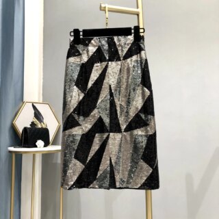 Photo d'une jupe mi-longue à sequins motifs géométriques accroché à un cintre sur un portant dans un décor moderne