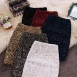 Photo de plusieurs jupes fourreaux pailletées à sequins disposées les unes sur les autres sur un tapis à poils longs blanc
