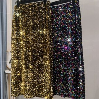 Photo de deux jupe mi-longue à sequins accrochées sur un cintre sur un portant , une dorée et une multicolore