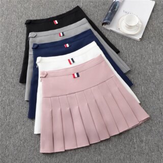 On voit un lot de jupes plissées sur un fond gris.
