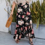 Photo d'une femme portant une jupe longue à fleurs avec un sac à main en osier et des talons