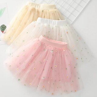 On voit trois jupes en tulle type tutu, une rose, une blanche et une jaune.