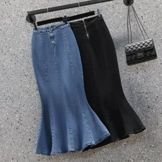 Photo de deux jupes sirène mi-longues en jean une bleu l'autre noire, sur cintre et un petit sac en cuir gaufré à bandoulière sur un patère