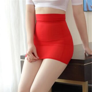 Femme portant une jupe moulante rouge et étant assise sur un meuble.