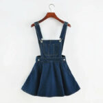 Photo d'une jupe salopette forme trapèze bleu foncée sur un cintre en bois marron