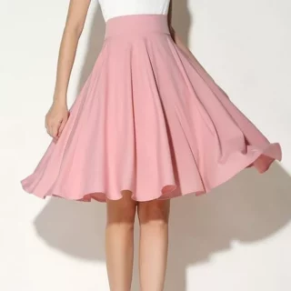 Photo d'une jeune femme portant une jupe patineuse midi rose à large ceinture avec un haut blanc