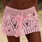 Photo d'une jeune femme portant une jupe de plage rose en crochet avec un cordon de serrage dans la même matière