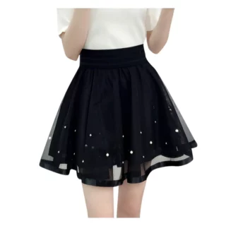 Photo d'une jeune fille en jupe patineuse noire en tulle gansé en bas avec petites perles et un haut blanc