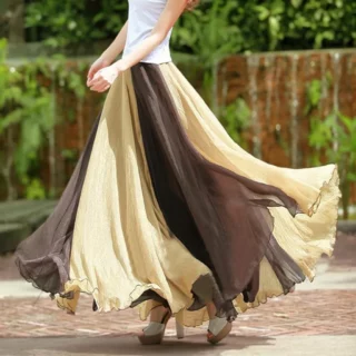 Photo d'une femme qui marche portant une jupe longue fluide bicolore jaune et marron