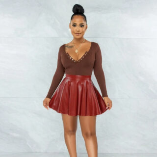 Photo représentant une femme portant une mini-jupe en cuir rouge patineuse et un body marron très décolleté