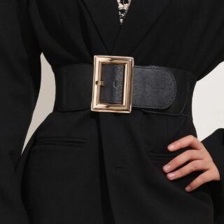 Photo d'une ceinture élastique à grosse boucle carrée sur une veste blazer.
