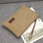 Pochette en Toile Vintage et Décontracté posé sur un canapé gris
