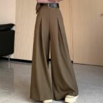 Jupe Culotte Classe et Distinguée portée par une femme avec un mur et une porte beige en fond et un canapé noir à gauche