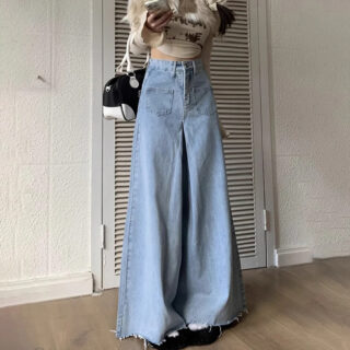 Pantalon Jupe Large et Taille Haute porté par une femme avec un sac devant un mur avec une porte derrière elle